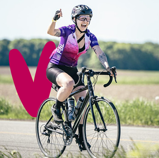 Une femme pédalant sur son vélo, levant le bras droit en signe de victoire.