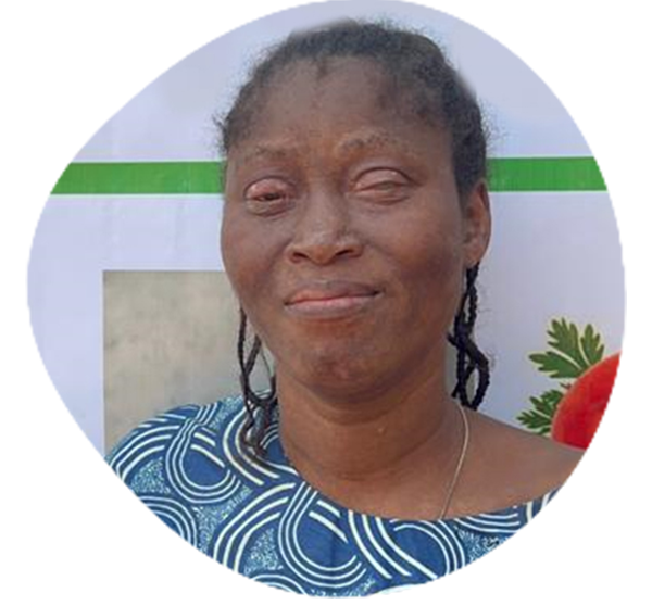 Femme avec un foulard jaune sur la tête et souriante tenant de nombreux haricots.