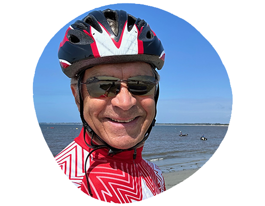 Photo d'un homme souriant portant un casque de vélo.