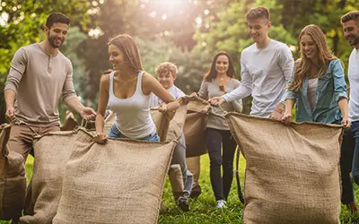 Des personnes participant à une course en sac.