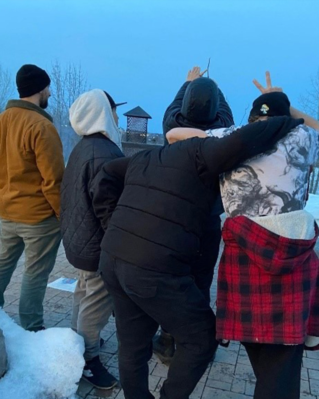 Groupe de jeunes adultes bras dessus bras dessous, de dos, en hiver — programme Envol vers l’autonomie, Fondation Ancrage Jeunesse.