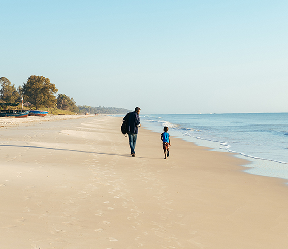 ReSea. Promenade d’un adulte et d’un enfant sur une plage calme au bord de la mer.