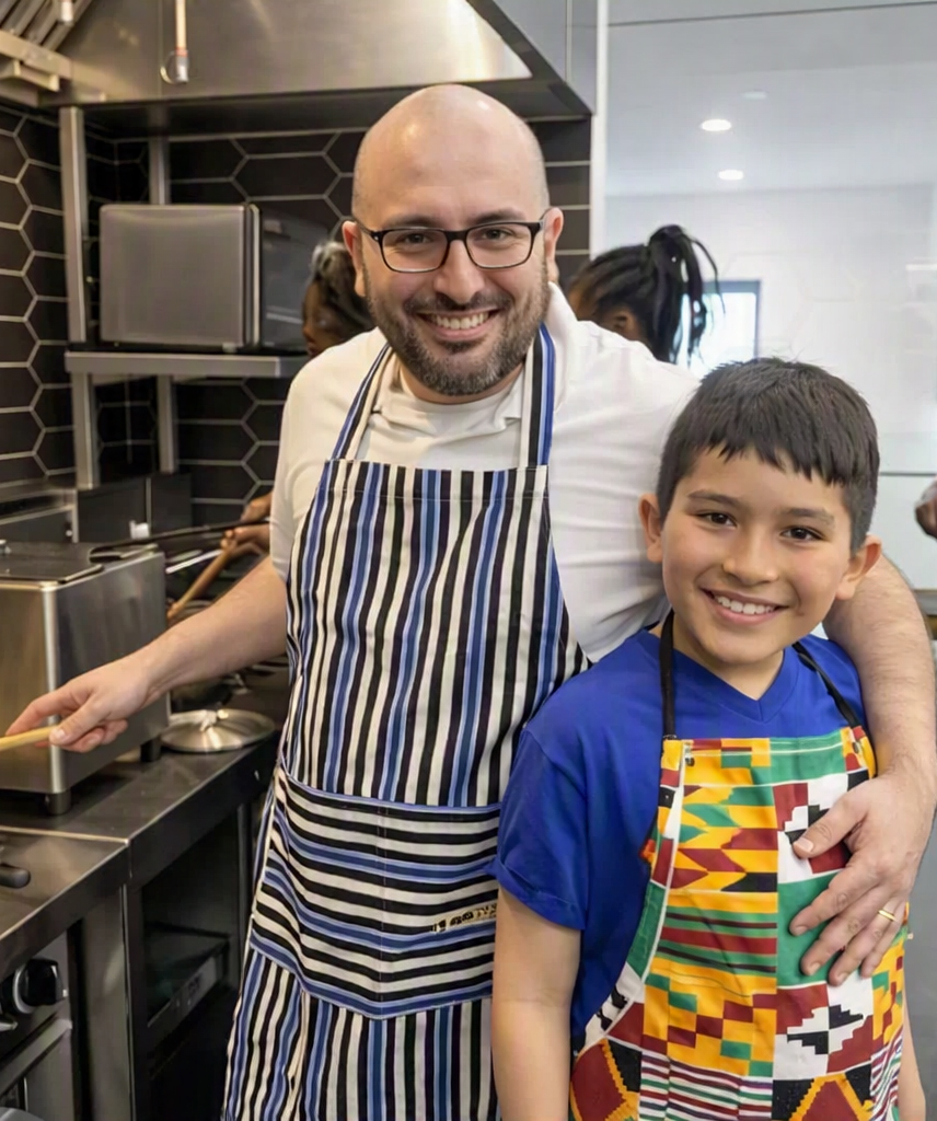 Pour la sécurité alimentaire, un adulte et un enfant cuisinent ensemble dans une cuisine moderne, portant des tabliers colorés.